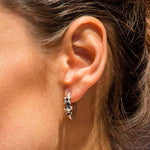 Annika Rutlin Raven collection forged decorative hoop earrings with star and moving jump rings shown on models ear