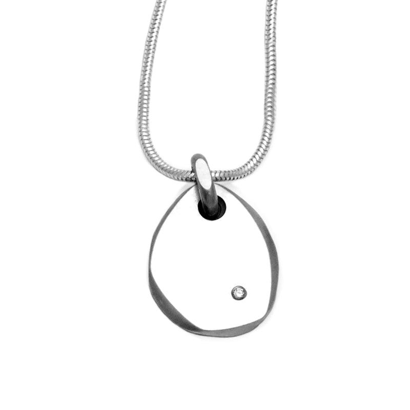 Elegantly simple pebble like flat silver pendant set with a high quality diamond by jeweller Annika Rutlin